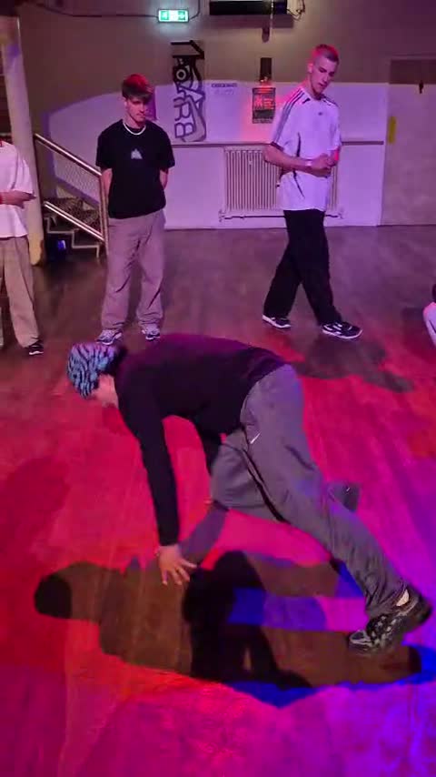 A breaker on the floor at a hip-hop event as the crowd watches